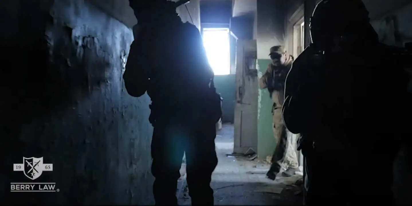 active duty military personnel clearing a building in the hallways